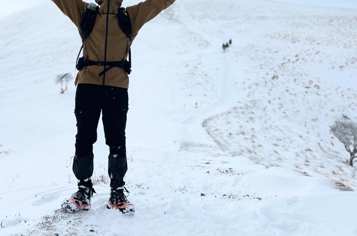 冬の鈴鹿・竜ヶ岳の雪の稜線で、ミレーのティフォン50000ウォームを着て、ゲイターとチェーンスパイクを付けて立っているところ